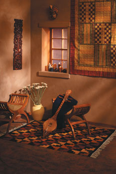 
Atop a wool rug blending the colors of the sky, the earth, and the greenery of Peru, a sueng klang, a four-stringed strumming instrument used in festivals and ceremonies in northern Thailand, rests against a teak and rattan bench made by Balinese artist Wayan Pastika (all from Novica.com). Cushioning the sueng is a naturally dyed kid-mohair throw from New Zealand (womankind.com). The walls are adorned with a Zimbabwean potato print wall hanging, a Balinese mahogany relief panel depicting the interaction of flora and fauna, and a hibiscus and batik mask (all from Novica.com). Cornhusk flowers handmade in Honduras (available from aid2artisans.org) and safari candles from Zimbabwe (Novica.com) complete this exotic room.
